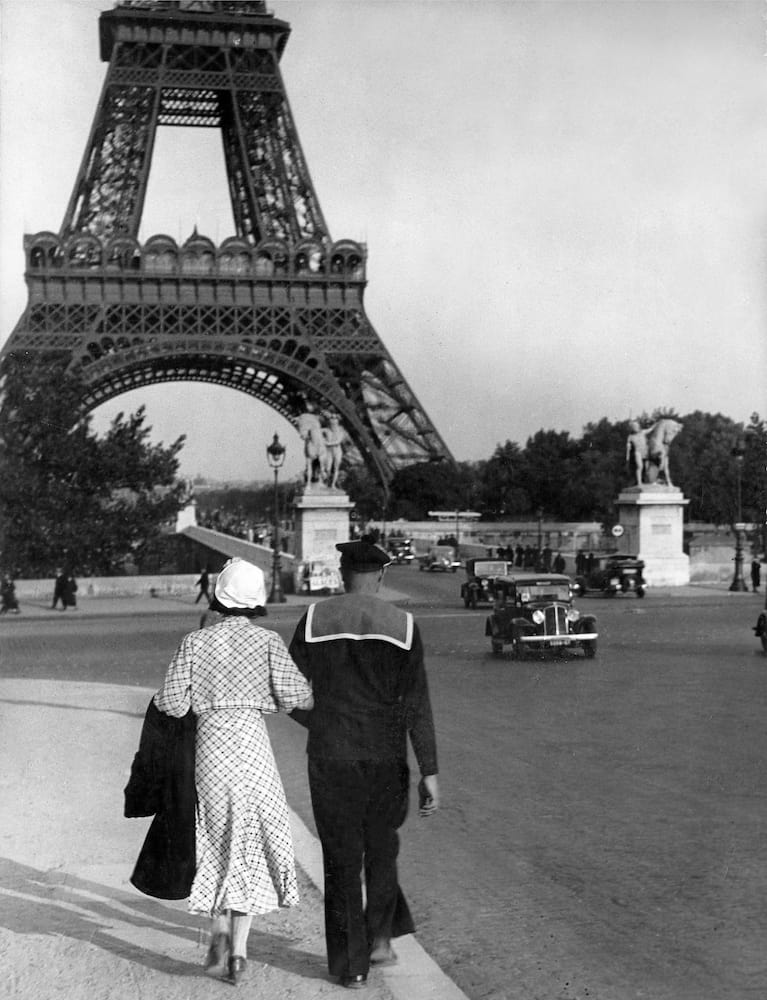 Uno coppia cammina di fronte alla torre eiffel
