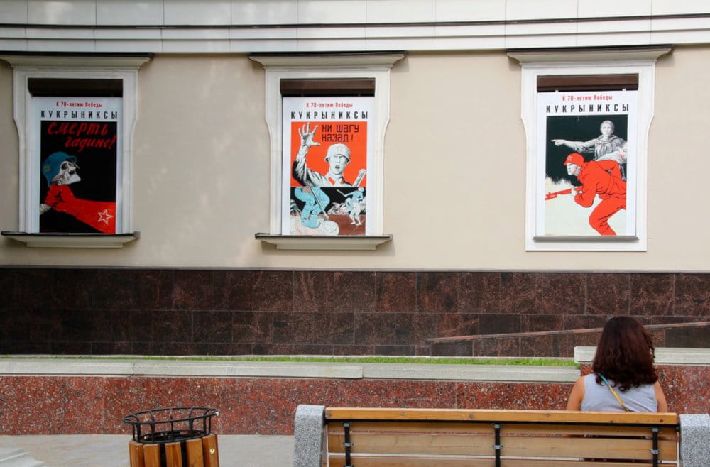 Una donna seduta di fronte a una serie di poster dell'unione sovietica