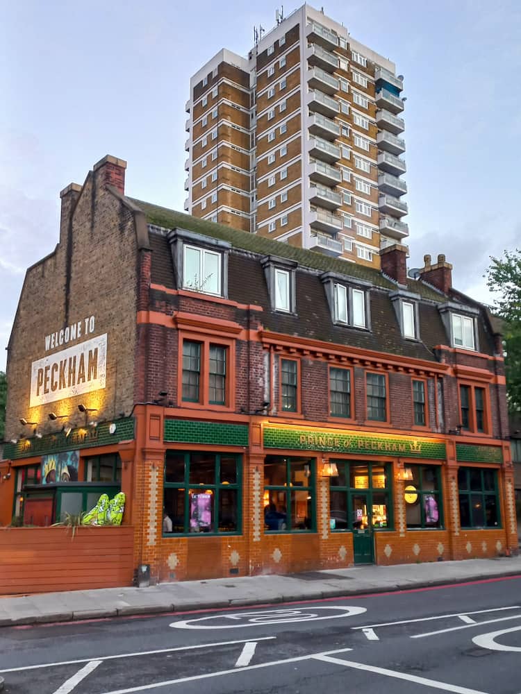 Il tradizionale pub Prince of Peckham con sullo sfondo un palazzo moderno di più piani